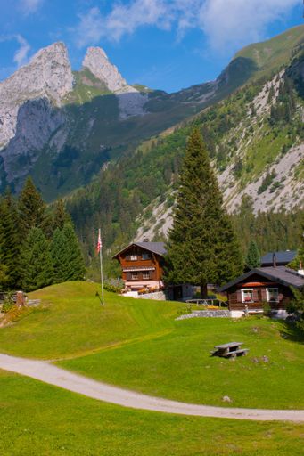 The beautiful green view of a mountain and field with wooden houses in Valais, Switzerland