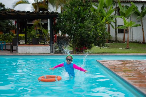 A little girl with swimming goggles having fun in the pool