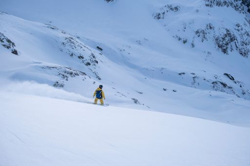 A bright winter morning in the hills of Switzerland with a person snowboarding