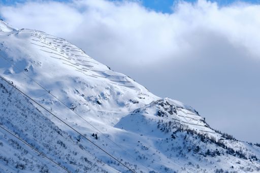 A closeup shot of the snowy mountain with the cloudy sky on the background in Andermatt, Switzerland