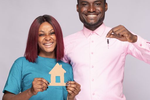 A happy African couple holding a smal wooden house together. Family concept