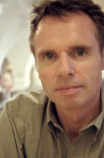 A vertical selective closeup shot of a Caucasian male with gray eyes staring blankly into the camera