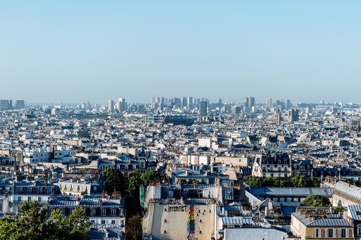 A beautiful aerial shot of a city full of high buildings with the background of blue sky