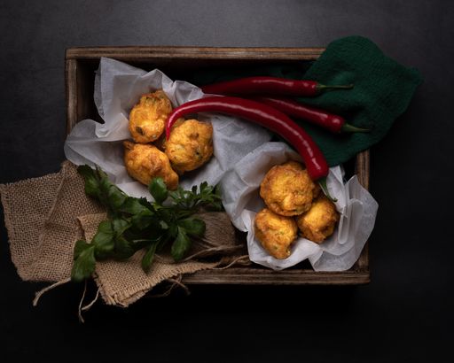 A top view of pies, red peppers and greens in a box