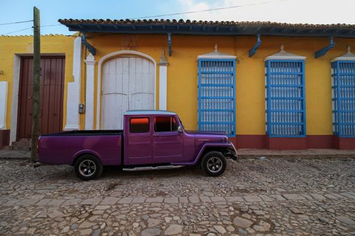 A beautiful view of a parked car on the street in Trinidad under the blue sky