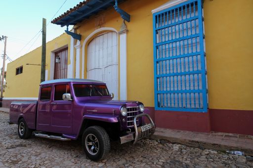 A beautiful view of a parked car on the street in Trinidad under the blue sky