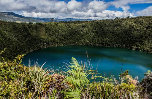 A landscape of the Laguna del Cacique Guatavita surrounded by greenery under the sunlight in Colombia