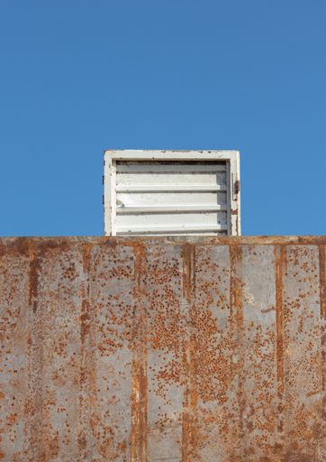A vertical shot of an abstract background of the rusty door and white door