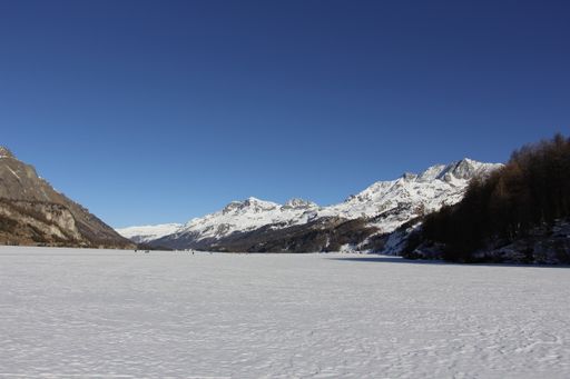 A landscape view of snowy mountains under a blue sky on a sunny day