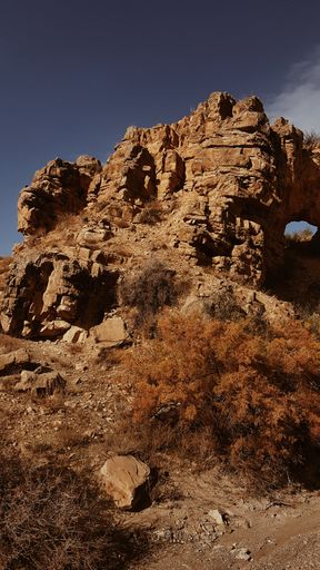 A vertical shot of rocky cliff under a  gloomy sky