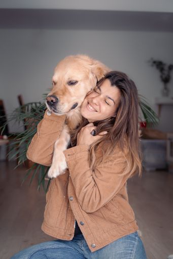A vertical shot of a dog hugging his owner
