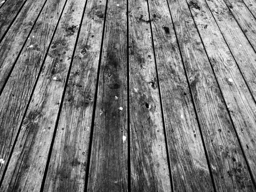 A grayscale shot of a wooden deck perfect for background
