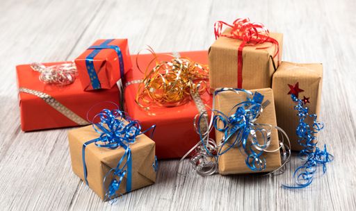 A closeup of Christmas gifts on a white painted wooden surface