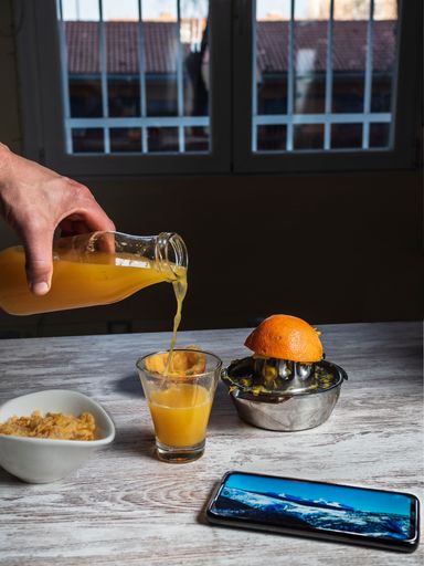 A vertical  shot of a freshly made orange juice with oranges