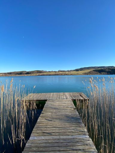 A beautiful shot of the lake and mountains from a wooden bridge