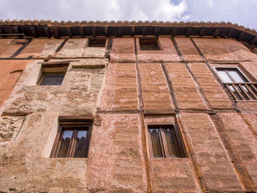 A low angle shot of an old building with weathered walls and windows