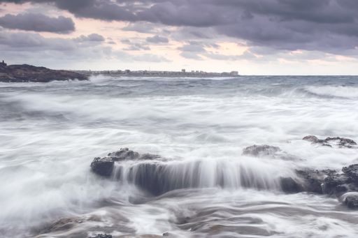 The rocks surrounded by the sea with long exposure during the sunset - perfect for wallpapers