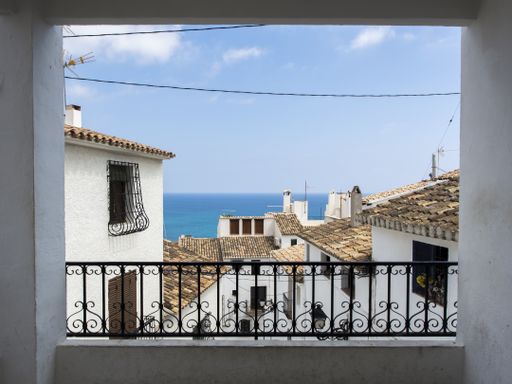 A view of the buildings and the sea under the sunlight from a window in Altea, Spain