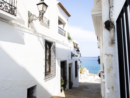 The old white buildings on the shore of the sea on a sunny day