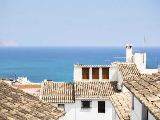 A beautiful view of white buildings and the sea with a clear skyline in Altea, Spain