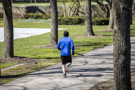 People are enjoying walks in the parks of downtown Chicago wearing masks and gloves despite the fears of Covid-19 corona virus. the city is shutdown