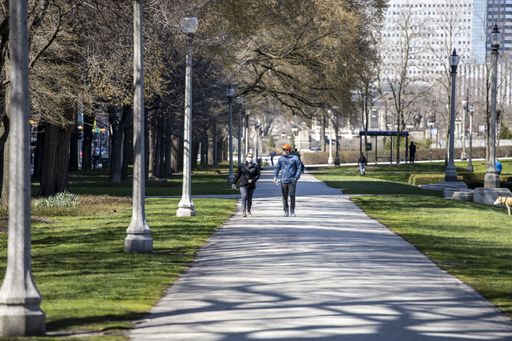 People are enjoying walks in the parks of downtown Chicago wearing masks and gloves despite the fears of Covid-19 corona virus. the city is shutdown
