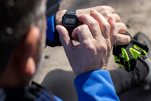 A high angle shot of a cyclist checking his pulse