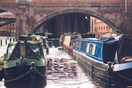 The boats in a canal under the bridge in Manchester, UK