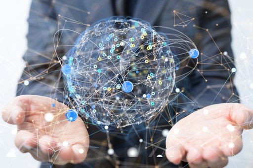A businessman holding a digital render of a global network