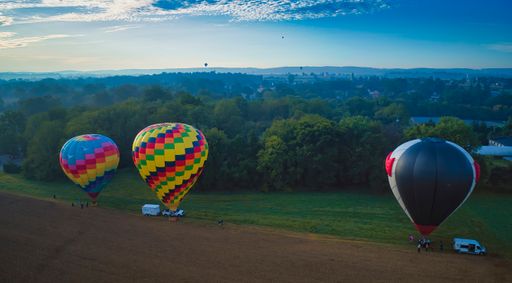 A multiple hot air balloons land in Farmlands as Amish Look on