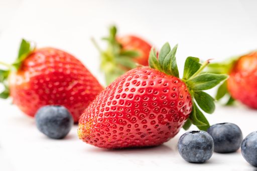 A selective closeup shot of ripe strawberries and blueberries