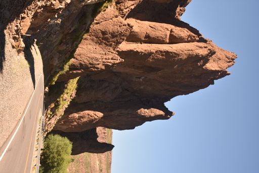 A vertical shot of the empty road against the background of massive rocks.