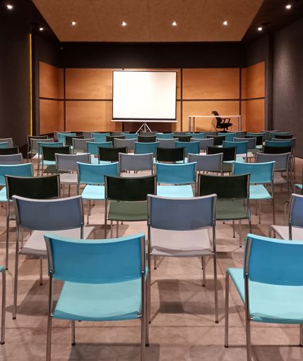 shot of a modern empty classroom or conference room with seats and a blank whiteboard for mockup. Education. Copyspace