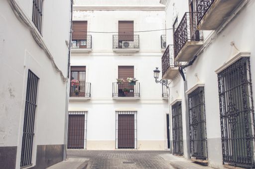 A low angle shot of the facade of the old white picturesque houses captured in Spain