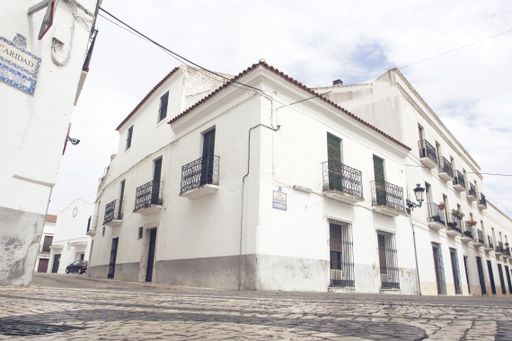 A low angle shot of the facade of the old white picturesque houses captured in Spain