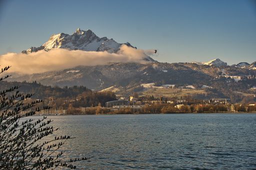 A beautiful landscape view of Mount Pilatus on water against a blue sky in Lucerne in Switzerland
