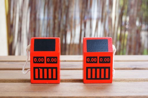 A selective focus shot of red miniature gas stations on a wooden table