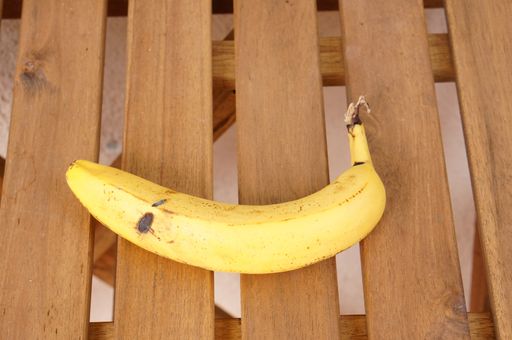 A high angle shot of a banana on a wooden surface