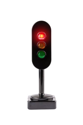 A miniature traffic light isolated on a white background