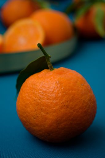 A vertical shot of fresh juicy tangerine with blurred background