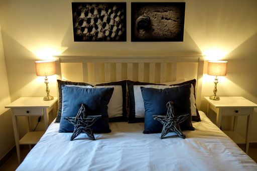 The beautiful bedroom design with dark blue pillows and stars on the bed.