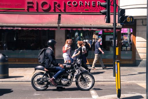 A photo of the man on the motorbike in the busy street of London