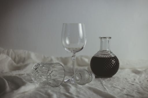 A closeup shot of glasses next to a vase full of wine
