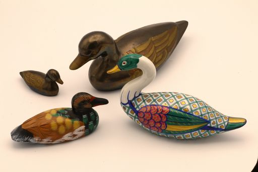 A high angle shot of colorful souvenir ducks on the table under the lights
