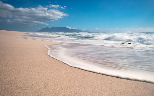The beach surrounded by the sea with long exposure under the sunlight at daytime - great for wallpapers