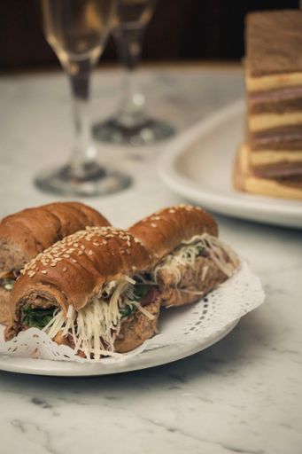 A vertical closeup shot of delicious sandwiches on a white plate on a marble table