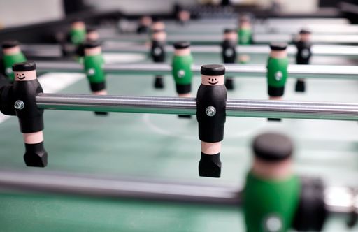A selective focus shot of table soccer with green and black figures