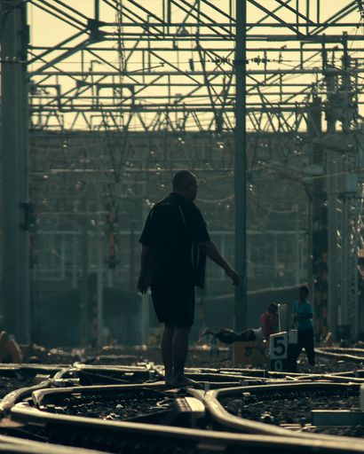 A person standing on rails in a railway station