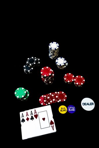 A vertical shot of poker chips and cards isolated on black background