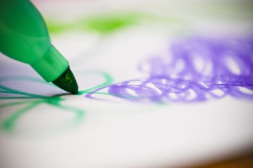 A selective focus closeup photography of a colorful green marker drawing on a white paper